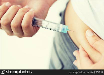 medicine, diabetes, glycemia, health care and people concept - close up of woman hands making injection with insulin pen or syringe. close up of hands making injection by insulin pen