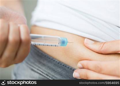 medicine, diabetes, glycemia, health care and people concept - close up of woman hands making injection with insulin pen or syringe