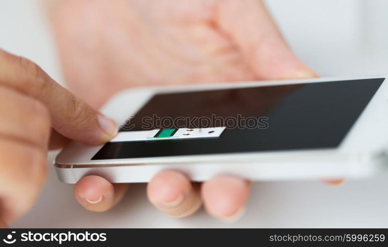 medicine, diabetes, glycemia, health care and people concept - close up of woman hands with smartphone and test stripe checking blood sugar level by glucometer application at home