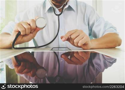 Medicine doctor hand holding stethoscope with modern tablet computer as medical network concept