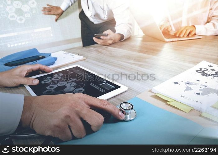 Medicine doctor hand working with modern computer and digital pro tablet with his team with digital medical diagram on wooden desk as medical concept