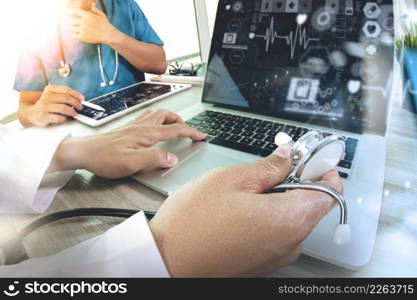 Medicine doctor hand working with modern computer and digital pro tablet with his team with digital medical diagram on wooden desk as medical concept