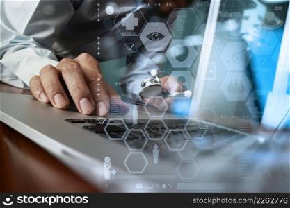Medicine doctor hand working with modern computer and medical diagram layers on wooden desk as medical concept
