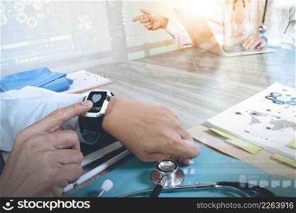 Medicine doctor hand working with modern smart watch and digital pro tablet with his team on wooden desk as medical concept