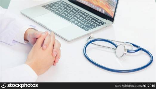 Medicine doctor&rsquo;s working on desk. Closeup of Stethoscope. Physician man video call sit hand in hand and listen patient explain on front laptop computer at hospital office, Healthcare medic concept