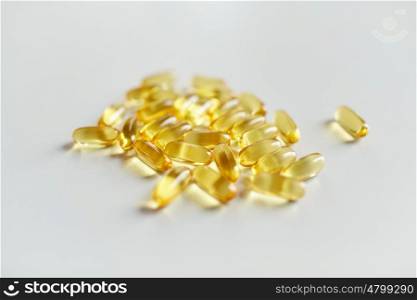 medicine, drugs, healthcare, food supplements and pharmaceutics concept - cod liver oil or omega 3 gel capsules