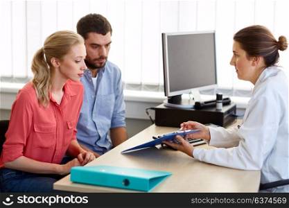 medicine, fertility and healthcare concept - couple visiting doctor at family planning clinic. couple visiting doctor at family planning clinic