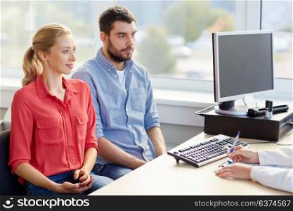 medicine, fertility and healthcare concept - happy couple visiting doctor at family planning clinic. couple visiting doctor at family planning clinic