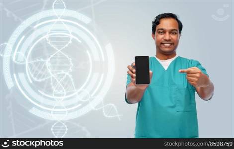 medicine, genetics and technology concept - happy smiling doctor or male nurse in blue uniform showing smartphone over dna molecule projection on grey background. smiling doctor with smartphone over dna projection
