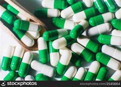 medicine green pills on white background on wooden spoon. sorted pharmaceutical. medicine green pills on white background on a wooden spoon. sorted pharmaceutical