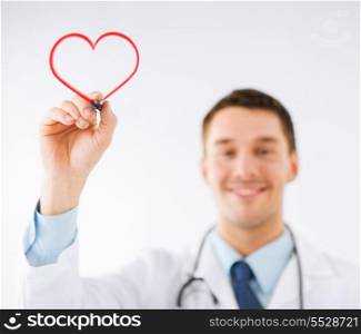 medicine, health and hospital concept - male doctor drawing heart in the air with marker