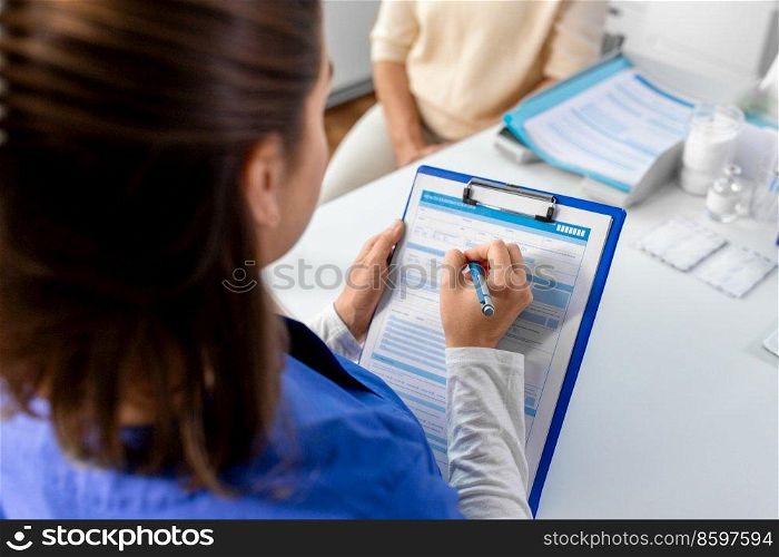 medicine, health and vaccination concept - close up of doctor with clipboard and senior woman at hospital. doctor with clipboard and senior woman at hospital