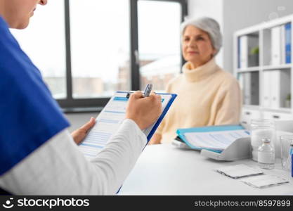 medicine, health and vaccination concept - close up of doctor with clipboard and senior woman at hospital. doctor with clipboard and senior woman at hospital