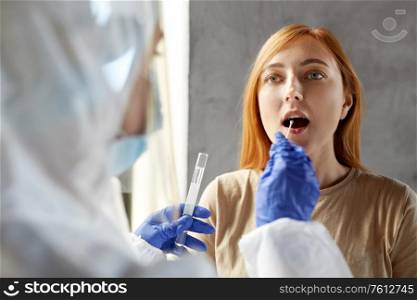 medicine, health and virus concept - doctor or healthcare worker in protective wear, medical mask and face shield making coronavirus test and taking sample from patient. doctor in protective wear making coronavirus test