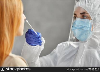 medicine, health and virus concept - doctor or healthcare worker in protective wear, medical mask and face shield making coronavirus test and taking sample from patient. doctor in protective wear making coronavirus test