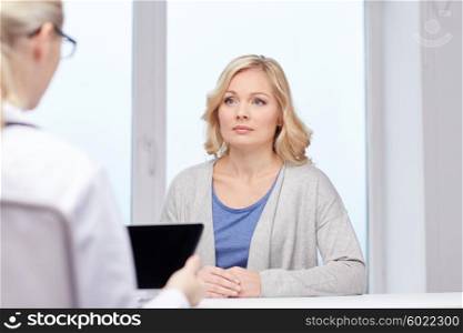 medicine, health care and people concept - doctor with tablet pc computer and woman meeting at hospital