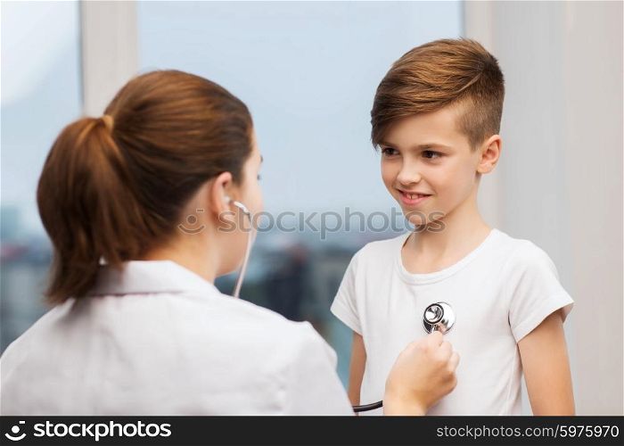 medicine, health care and people concept - female doctor or nurse with stethoscope listening to happy child chest in hospital