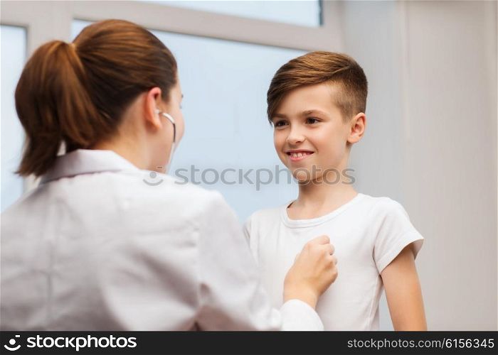 medicine, health care and people concept - female doctor or nurse with stethoscope listening to happy child chest in hospital