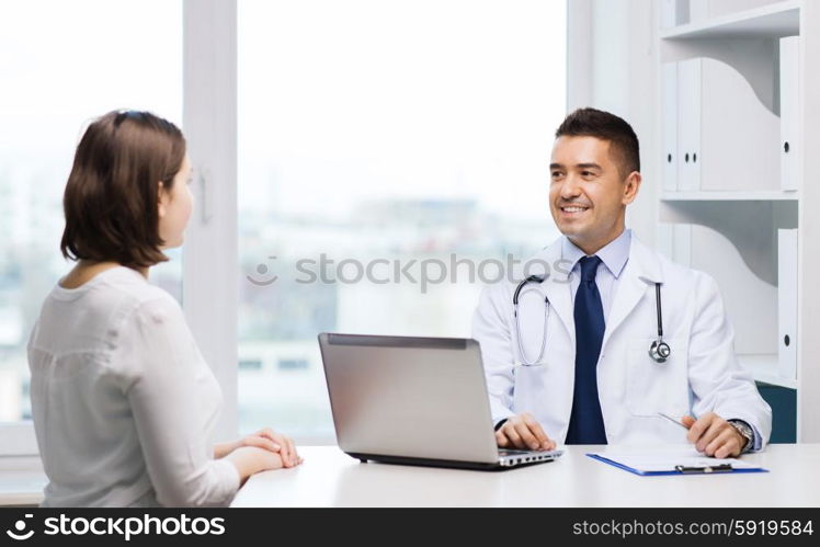 medicine, health care and people concept - smiling doctor with laptop computer and young woman meeting at hospital