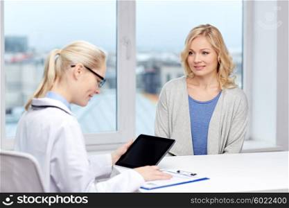 medicine, health care and people concept - smiling doctor with tablet pc computer and woman meeting at hospital