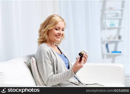 medicine, health care and people concept - woman looking at jars with medicine at home or hospital office