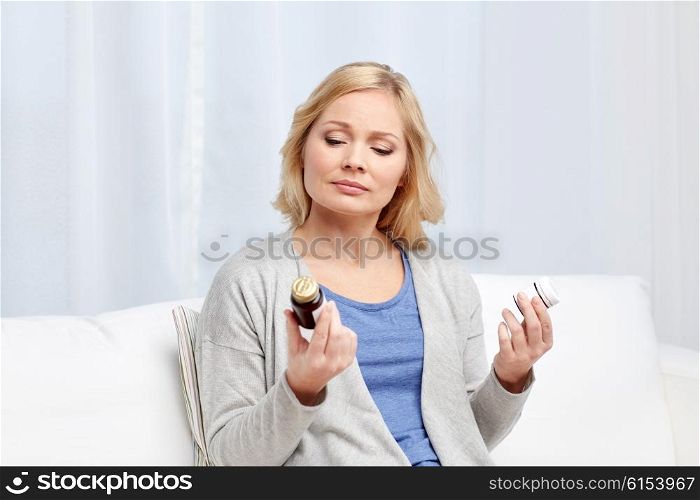 medicine, health care and people concept - woman looking at jars with medicine at home or hospital office