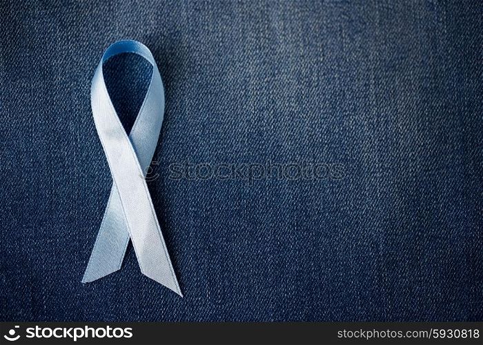 medicine, health care and symbolics concept - close up of blue prostate cancer awareness ribbon