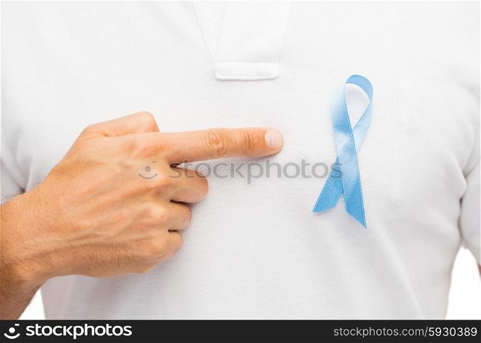 medicine, health care, gesture and people concept - close up of male hand pointing to blue prostate cancer awareness ribbon on his chest
