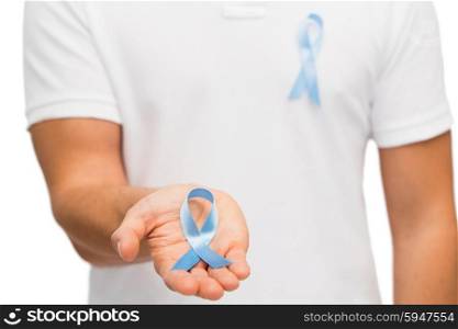 medicine, health care, gesture and people concept - close up of male hand holding blue prostate cancer awareness ribbon