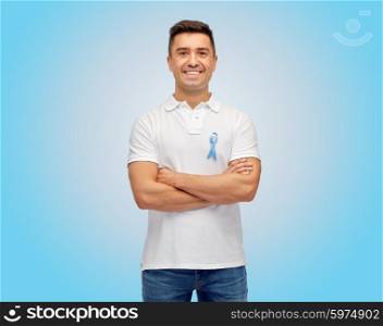 medicine, health care, gesture and people concept - middle aged latin man in t-shirt with blue prostate cancer awareness ribbon pointing finger on himself