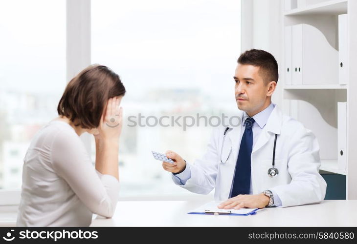 medicine, health care, medication and people concept - doctor with clipboard giving pills to young woman at hospital