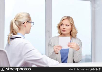 medicine, health care, meeting and people concept - doctor giving medical prescription or certificate to woman at hospital