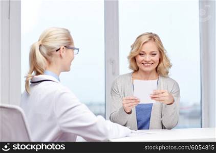 medicine, health care, meeting and people concept - smiling doctor giving medical prescription or certificate to woman at hospital