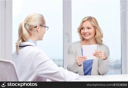 medicine, health care, meeting and people concept - smiling doctor giving medical prescription or certificate to woman at hospital