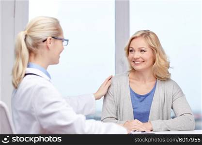 medicine, health care, meeting and people concept - smiling doctor talking to woman patient at hospital