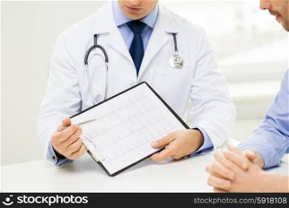medicine, health care, people and cardiology concept - close up of f male doctor and patient hands with cardiogram on clipboard