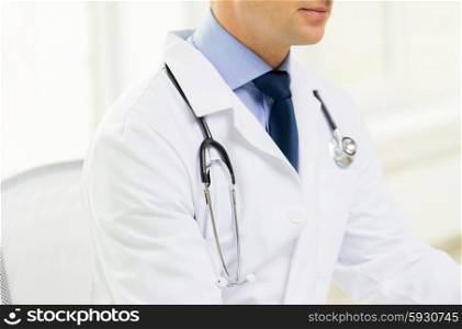 medicine, health care, people and profession concept - close up of male doctor with stethoscope at medical office in hospital