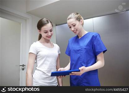 medicine, health care, technology and people concept - smiling female doctor or nurse with tablet pc computer and young girl meeting at hospital