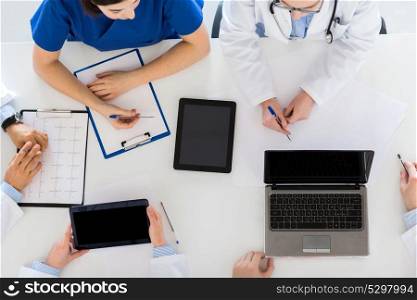 medicine, healthcare and cardiology concept - group of doctors with cardiogram, clipboard, tablet pc and laptop computers at hospital. doctors with cardiogram and computers at hospital