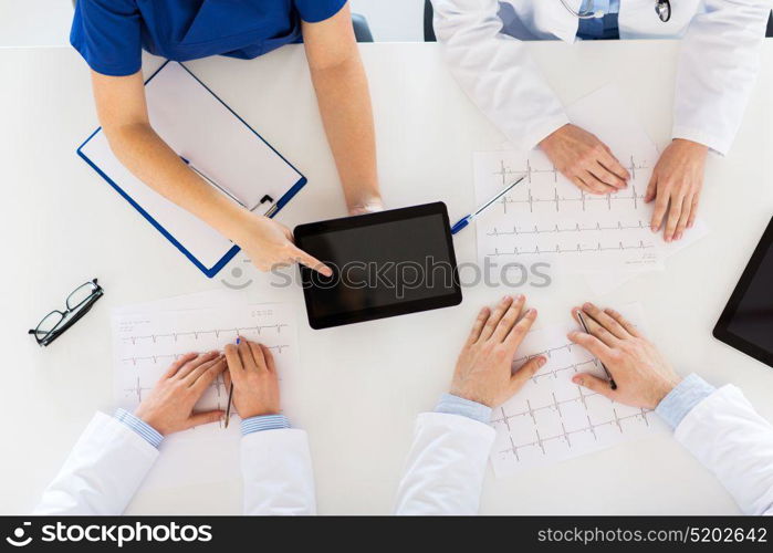 medicine, healthcare and cardiology concept - group of doctors with cardiograms, clipboard and tablet pc computer at hospital. doctors with cardiograms and tablet pc at hospital