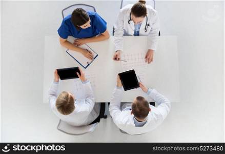 medicine, healthcare and cardiology concept - group of doctors with cardiograms, clipboard and tablet pc computers at hospital. doctors with cardiogram and tablet pc at hospital