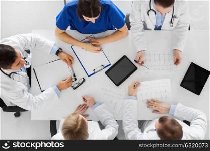 medicine, healthcare and cardiology concept - group of doctors with cardiograms, clipboard and tablet pc computers at hospital. group of doctors with cardiograms at hospital