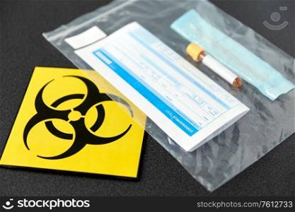 medicine, healthcare and pandemic concept - beaker with test, cotton swab with medical report in plastic zipper bag and biohazard caution sign. beaker with test, cotton swab and medical report