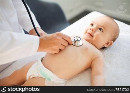 medicine, healthcare and pediatrics concept - close up of female doctor with stethoscope listening to baby girl&rsquo;s patient heartbeat or breath at clinic or hospital. doctor with stethoscope listening to baby patient