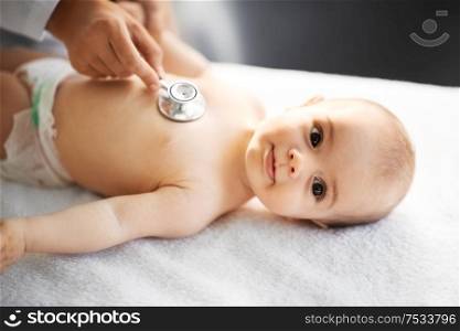 medicine, healthcare and pediatrics concept - close up of female doctor with stethoscope listening to baby girl&rsquo;s patient heartbeat or breath at clinic or hospital. doctor with stethoscope listening to baby patient