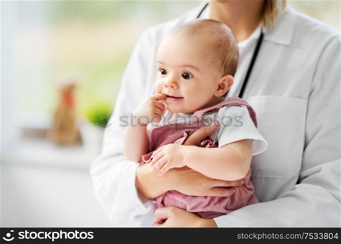 medicine, healthcare and pediatrics concept - close up of female pediatrician doctor or nurse holding baby girl patient at clinic or hospital. female pediatrician doctor with baby at clinic