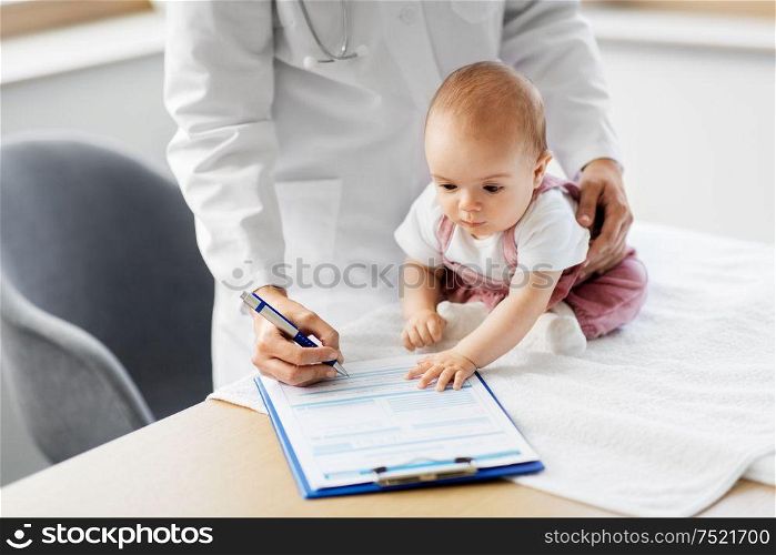 medicine, healthcare and pediatrics concept - female pediatrician or neuropathist doctor or nurse checking baby girl patient&rsquo;s health and making notes to clipboard at clinic or hospital. female pediatrician doctor with baby at clinic