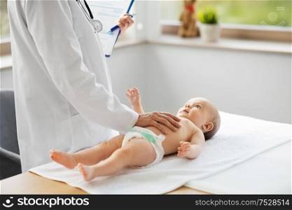 medicine, healthcare and pediatrics concept - female pediatrician or neuropathist doctor or nurse checking baby patient&rsquo;s at clinic or hospital. female pediatrician doctor with baby at clinic