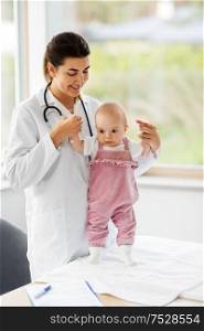 medicine, healthcare and pediatrics concept - female pediatrician or neuropathist doctor or nurse checking baby girl patient&rsquo;s health at clinic or hospital. female pediatrician doctor with baby at clinic