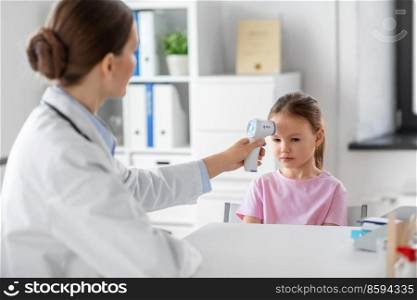 medicine, healthcare and pediatry concept - female doctor or pediatrician measuring little girl patient’s temperature with infrared forehead thermometer at clinic. female doctor and little girl patient at clinic
